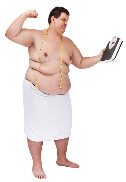 Diätfrust. Ein übergewichtiger junger Mann, der wütend aussieht und kurz davor ist, eine Gewichtswaage zu schlagen. - Foto, Bild