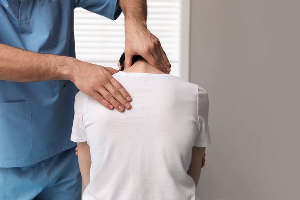 Orthopedist examining woman's neck in clinic, closeup. Scoliosis treatment - Foto, Bild