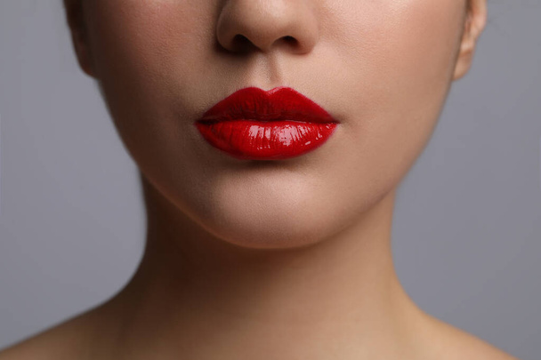 Closeup view of woman with beautiful full lips on grey background - Fotografie, Obrázek