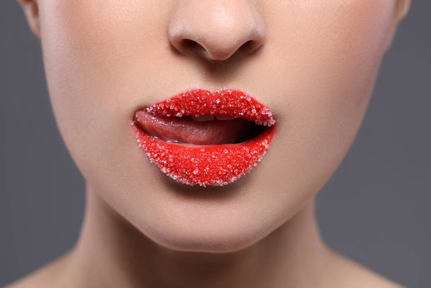 Woman with beautiful lips covered in sugar on grey background, closeup - 写真・画像