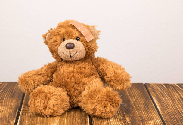 teddy bear with a toy on a wooden background - Fotoğraf, Görsel