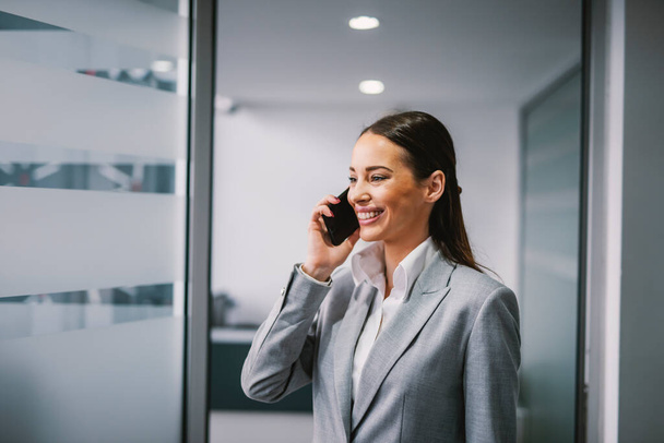 A businesswoman having phone call at workplace. - Фото, зображення