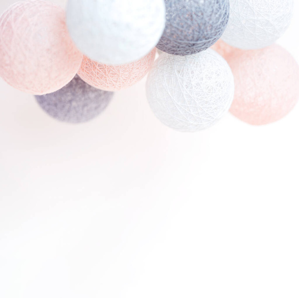 Holiday concept. Illumination from balls with threads. Jewelry and accessories. Birthday. Pastel shades - 写真・画像