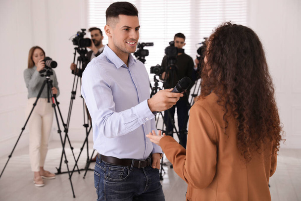 Professional journalist interviewing young African American woman indoors - Photo, Image