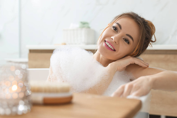 Beautiful woman enjoying bubble bath at home - Foto, Imagen