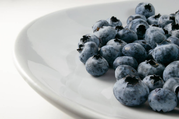 fresh blueberries in a bowl on a white background - Foto, Bild