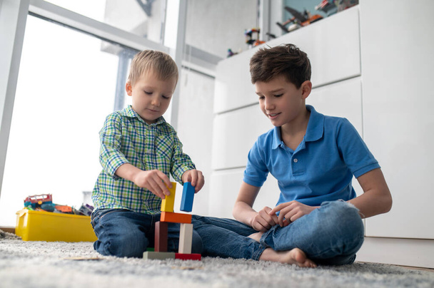 Concentrated creative little boy assembling toy blocks - Valokuva, kuva