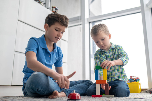 Focused involved child joining together building bricks - Photo, Image