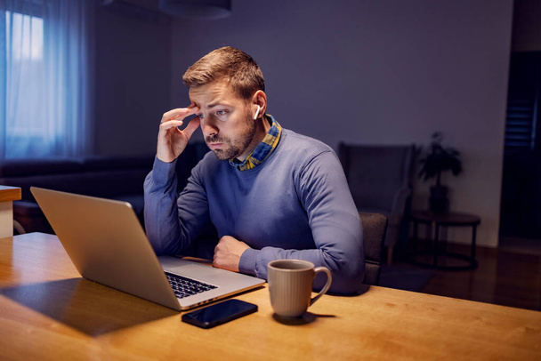 Egy vállalkozó, akinek problémái vannak a jelentéssel és a laptopot nézi otthon. - Fotó, kép