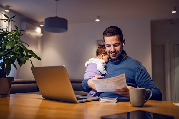 An entrepreneur working remotely from home and babysits his baby girl. - Φωτογραφία, εικόνα
