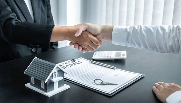 Zakończenie udanej transakcji nieruchomości, Broker i klient uścisk dłoni po podpisaniu umowy zatwierdzony formularz wniosku, dotyczące oferty kredytu hipotecznego i ubezpieczenia mieszkaniowego. - Zdjęcie, obraz