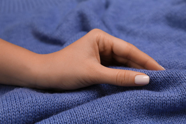 Woman touching soft blue fabric, closeup view - Foto, afbeelding