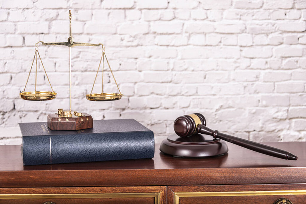 Wagi wymiaru sprawiedliwości z książkami prawniczymi na stole notariusza urzędującego. - Zdjęcie, obraz
