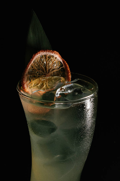cocktail with lemon and ice on black background - Fotoğraf, Görsel