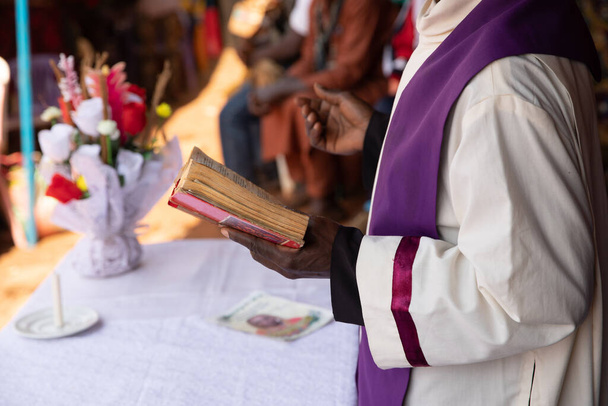 Африканський священик виконує месу і читає біблію під час святкування. - Фото, зображення