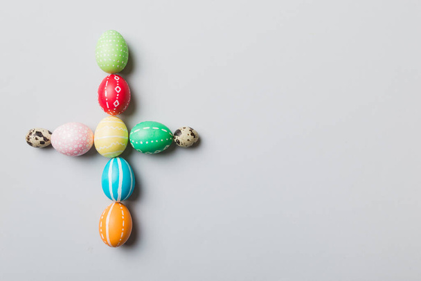 holiday preparation Multi colors Easter eggs on colored background, cross show the religious and secular side of Easter. Pastel color Easter eggs. holiday concept with copy space. - Photo, Image