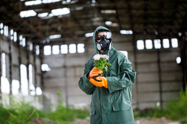 Koruyucu giysiler içinde bir dozimetrist radyasyon müfettişi ve gaz maskesi tehlike bölgesini inceliyor. Yakın plan. Çiçek. Ekolojik felaket - Fotoğraf, Görsel