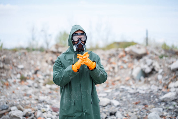 Un hombre con una máscara protectora y ropa protectora explora la zona de peligro. Catástrofe ecológica. enfoque selectivo - Foto, imagen