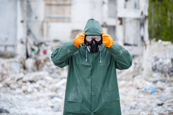 防護マスクと防護服を着た男が危険な放射線区域を探索する. - 写真・画像