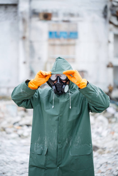 Mies suojelevassa naamiossa ja suojavaatteissa tutkii vaarallista radioaktiivista aluetta.. - Valokuva, kuva