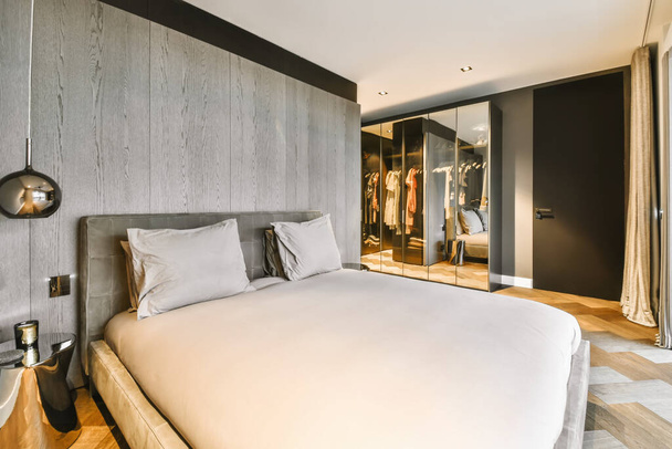 Atrakcyjna sypialnia w minimalistycznym stylu z miękkim podwójnym łóżkiem pokrytym - Zdjęcie, obraz