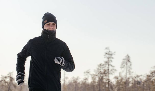 Toute la longueur d'un athlète d'âge moyen heureux qui court dans la nature par une journée d'hiver enneigée. Fitness en plein air, entraînement cardio, exercices en plein air - Photo, image