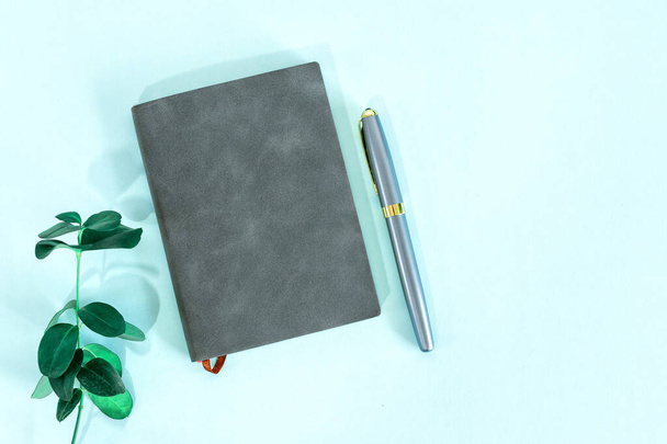 pusty notatnik z zielonymi liśćmi i długopisem  - Zdjęcie, obraz
