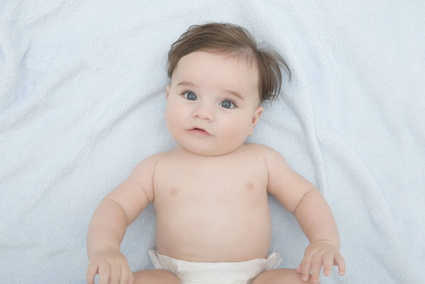 hermoso bebé niño de cuatro meses de edad acostado en una manta suave azul - Foto, Imagen
