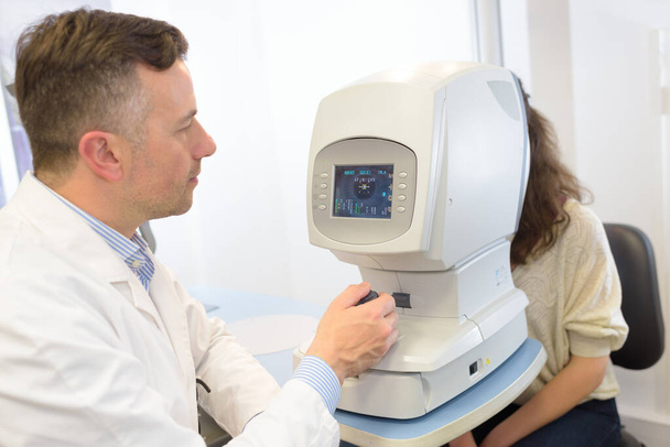 a doctor and retinal exam - Foto, Bild