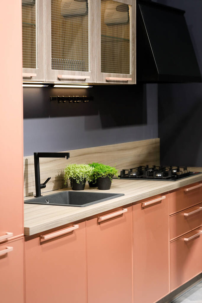 ピンクと木製のキャビネット付きの現代的なキッチン。選択的焦点. - 写真・画像