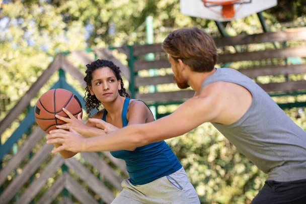 young athletic couple playing basketball - Φωτογραφία, εικόνα