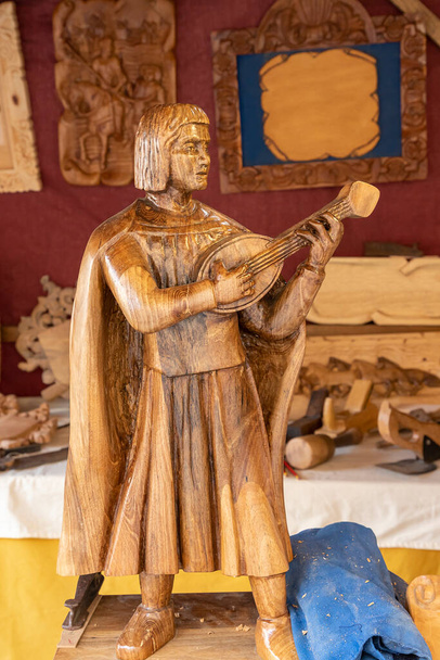 svislý pohled na řezbu dřeva zobrazující minstrela hrajícího na loutnu - Fotografie, Obrázek