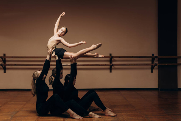 支援だ。現代バレエダンサーのグループ。現代美術。若い柔軟な運動選手の女性バレエダンサー。ダンスの恵み、インスピレーション、創造性の概念. - 写真・画像