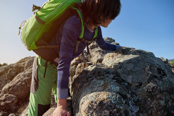 Adolescente con mochila escalando rocas en la naturaleza - Foto, imagen