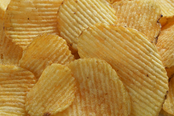 продовольственный фон с картофельными чипсами крупным планом - Фото, изображение