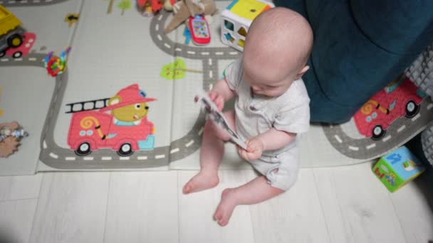Onnellinen pieni vauva leikkii ja ryömii huoneessa - Materiaali, video