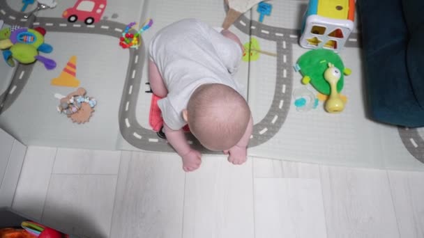 Gelukkige kleine baby spelen en kruipen door kamer - Video