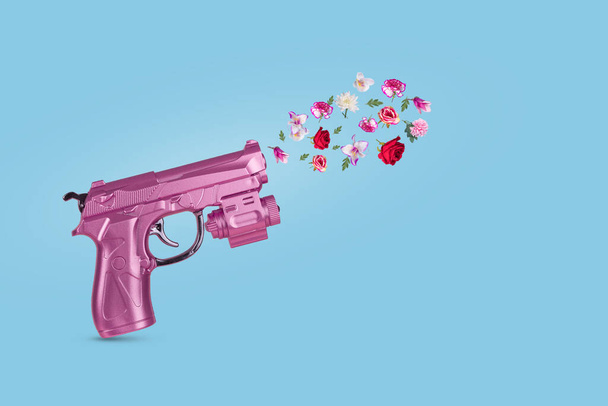 Pistola rosa disparando hermosas flores. Mínimo concepto de paz. Alto a la guerra. - Foto, Imagen