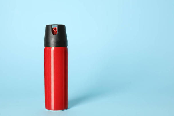 Bottle of gas pepper spray on light blue background. Space for text - Foto, afbeelding