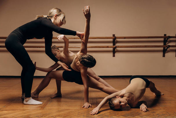 Bir grup küçük kız bir dans stüdyosunda grup antrenmanında bir koreografla yeni bir dans öğreniyorlar. - Fotoğraf, Görsel