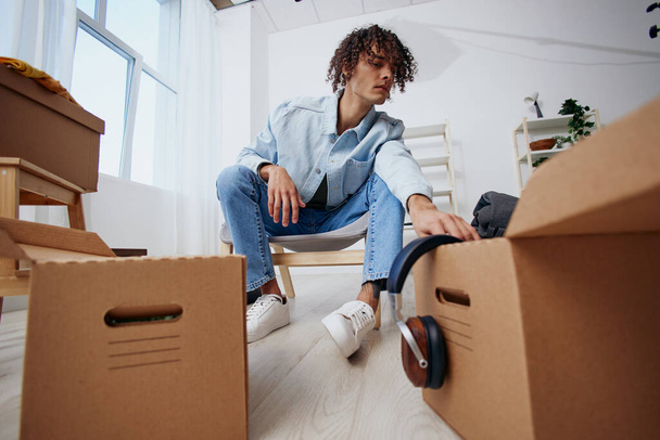 portrait of a man sitting on a chair with boxes moving Lifestyle - Photo, Image