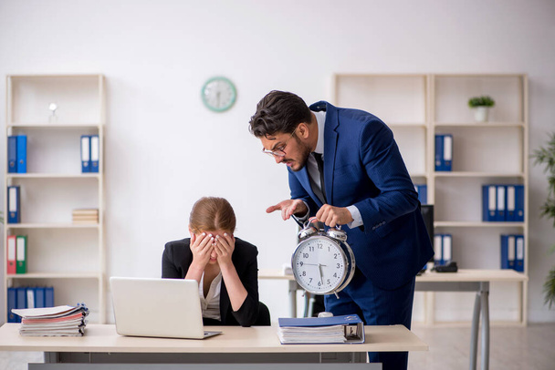 Αφεντικό και νεαρή γυναίκα γραμματέας στην έννοια της διαχείρισης του χρόνου - Φωτογραφία, εικόνα