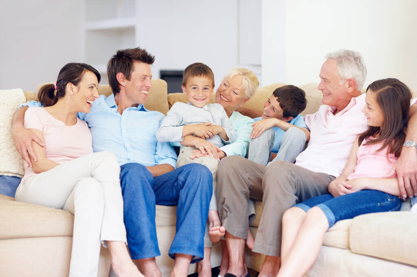 Τρεις γενιές μαζεύονται ευτυχισμένοι μαζί. Τρεις γενιές της οικογένειας κάθονται μαζί στοργικά στο lounge καναπέ. - Φωτογραφία, εικόνα