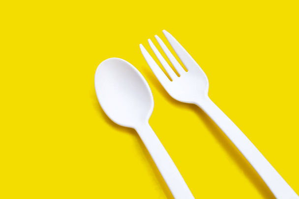 Fourchette et cuillère en plastique sur fond jaune. - Photo, image