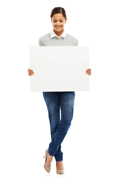 Presentando tu mensaje. Retrato de estudio de una joven atractiva sosteniendo un cartel en blanco aislado en blanco. - Foto, Imagen