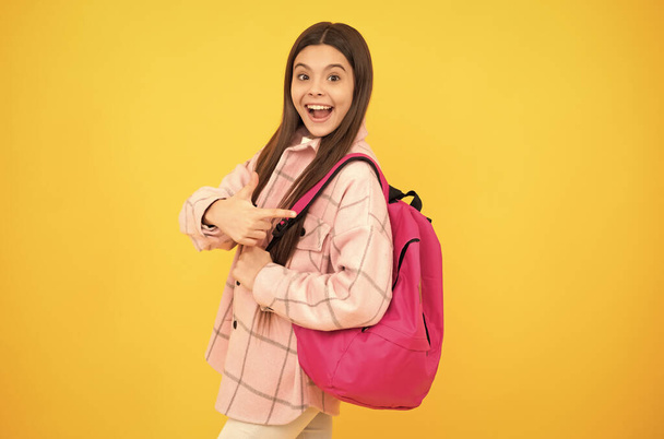 zurück zur Schule. überraschte Teenie-Mädchen im karierten Hemd. glückliches Kind lässigen Stil tragen Rucksack. - Foto, Bild