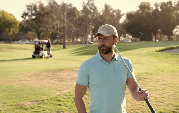retrato de golfista en gorra con club de golf mirando hacia otro lado. estilo de vida. hombre jugando juego - Foto, Imagen