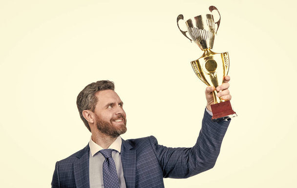 úspěšný muž v obleku držet mistr pohár s obchodní odměnou izolované na bílém, úspěch. - Fotografie, Obrázek