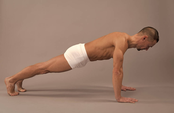 Wzmocnienie ramion i kręgosłupa. Człowiek Yogi pozuje na deski. Postawa deski do ćwiczeń w jodze - Zdjęcie, obraz