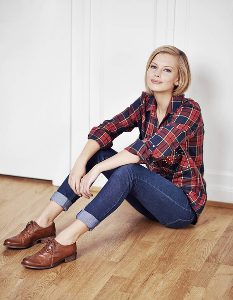Comfortable style. A portrait of a beautiful young woman sitting on a wooden floor at home. - Valokuva, kuva